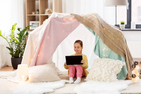 Petite fille avec tablette pc dans la tente des enfants à la maison — Photo