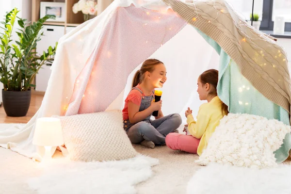 Little girls with torch light in kids tent at home — Stock Photo, Image