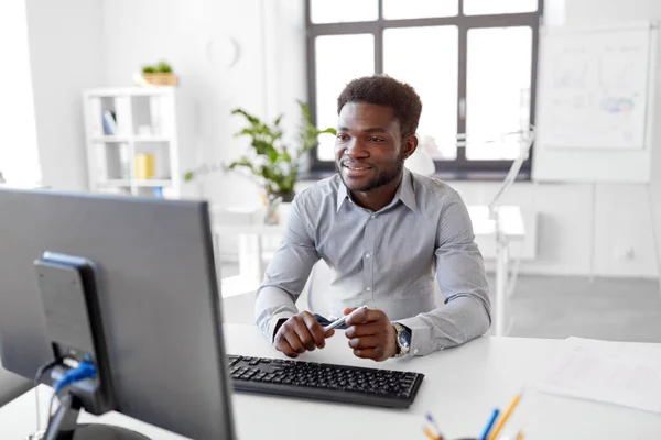 Empresario africano trabaja con computadora en la oficina — Foto de Stock