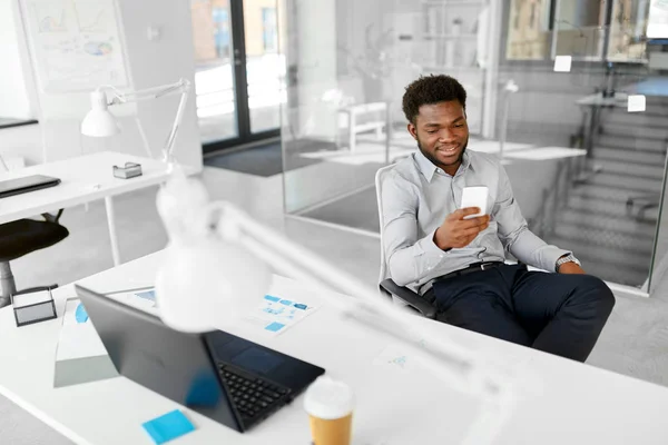 Homem de negócios com smartphone no escritório — Fotografia de Stock