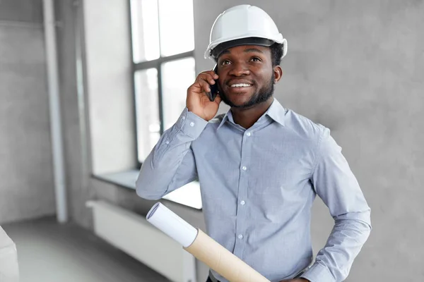 Architect with blueprint calling on smartphone — Stock Photo, Image