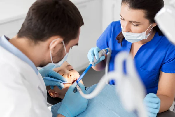 Dentista tratamiento de dientes de niño en la clínica dental — Foto de Stock