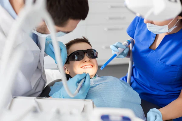 Dentiste traitant les dents d'enfant à la clinique dentaire — Photo