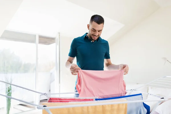 Usmívající se muž s prací a sušák na prádlo doma — Stock fotografie