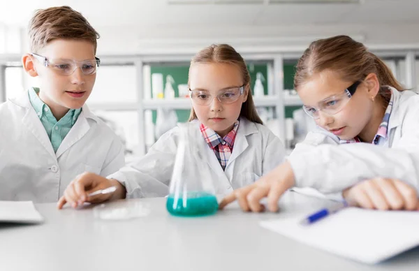 Niños con probeta que estudian química en la escuela — Foto de Stock