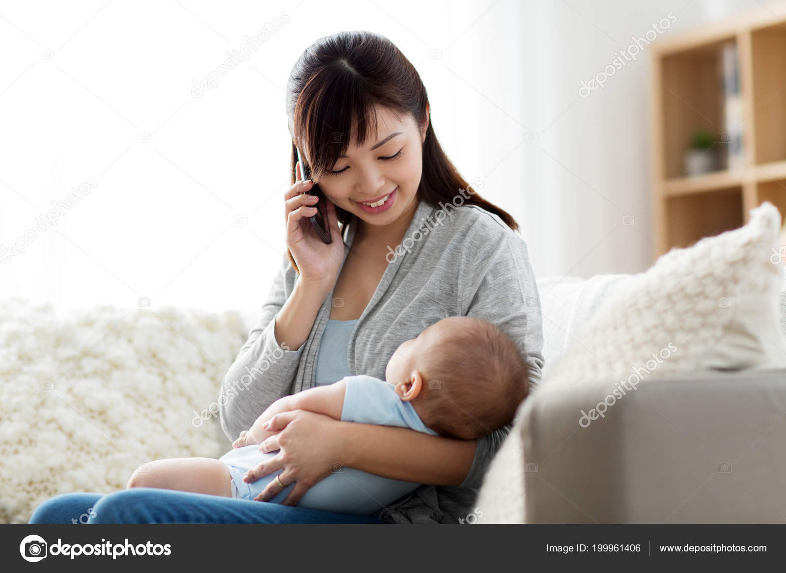 Mother with baby calling on smartphone at home — Stock Photo