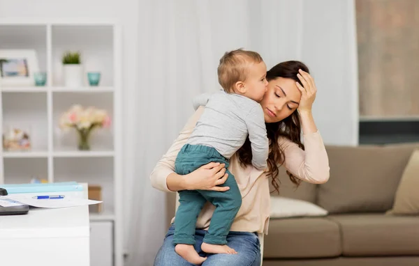 Müde Mutter mit Baby arbeitet zu Hause — Stockfoto