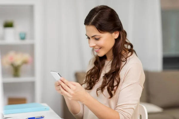 Mensagens mulher feliz no smartphone em casa — Fotografia de Stock