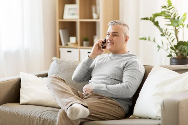 Šťastný muž volá na smartphone doma — Stock fotografie