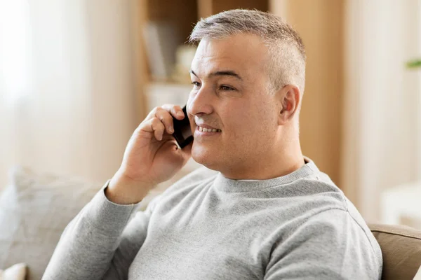 Homem feliz chamando no smartphone em casa — Fotografia de Stock