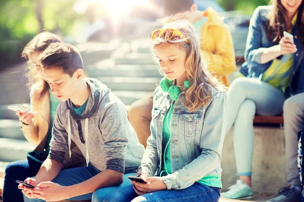 Teenage friends with smartphones outdoors — Stock Photo, Image