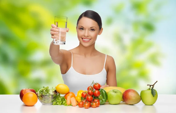 Woman with healthy food on table drinking water — Stock Photo, Image