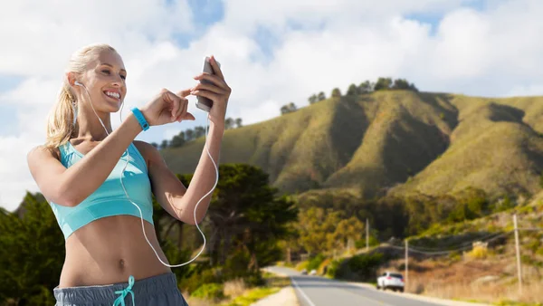 Frau mit Smartphone und Kopfhörer beim Sport — Stockfoto