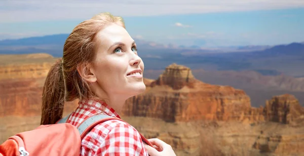 Mulher sorridente com mochila sobre grande canyon — Fotografia de Stock