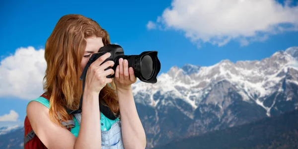 Женщина с рюкзаком и камерой над альпами гор — стоковое фото