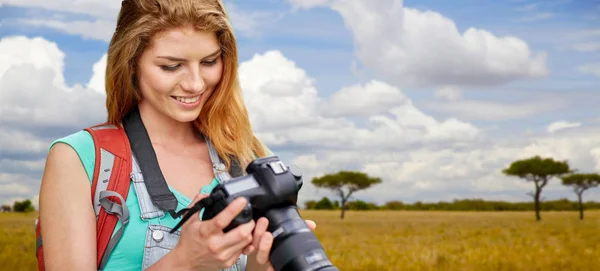 Žena s batohem a fotoaparát nad savannah — Stock fotografie