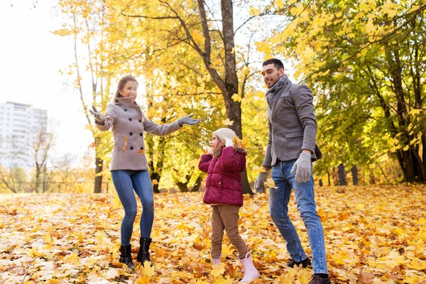 Šťastná rodina hraje s podzimní listí v parku — Stock fotografie