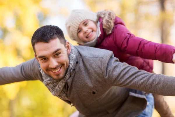 Счастливые отец и дочь играют в осеннем парке — стоковое фото