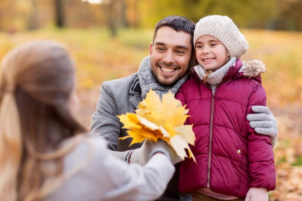 Šťastná rodina s maple listy na podzim park — Stock fotografie