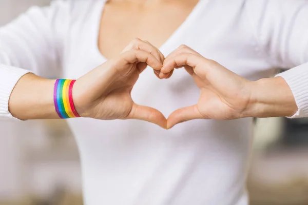 Mulher com consciência gay pulseira mostrando coração — Fotografia de Stock