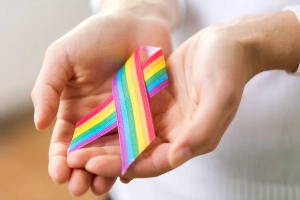 Femminile mani tenendo gay orgoglio consapevolezza nastro — Foto Stock