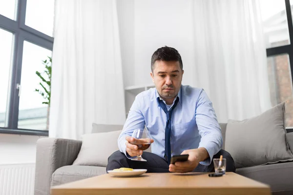 Homme ivre avec smartphone et alcool à la maison — Photo