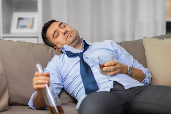 Borracho con botella de alcohol durmiendo en casa — Foto de Stock