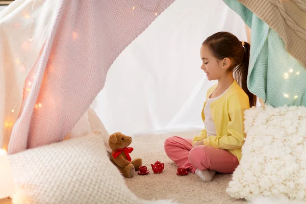 Menina brincando de festa de chá na tenda crianças em casa — Fotografia de Stock