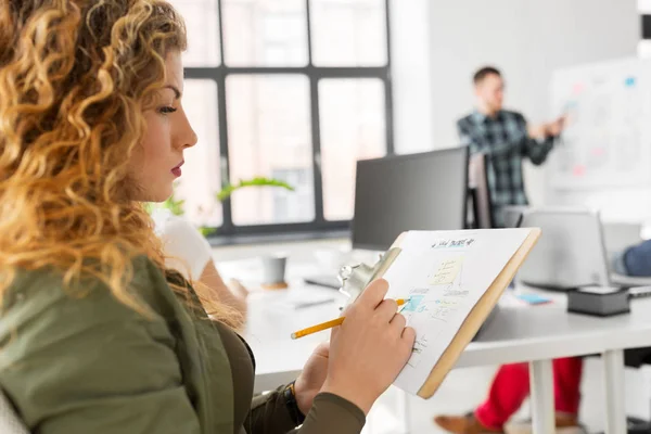 Office のクリップボード上のスケッチを持つ創造的な女性 — ストック写真