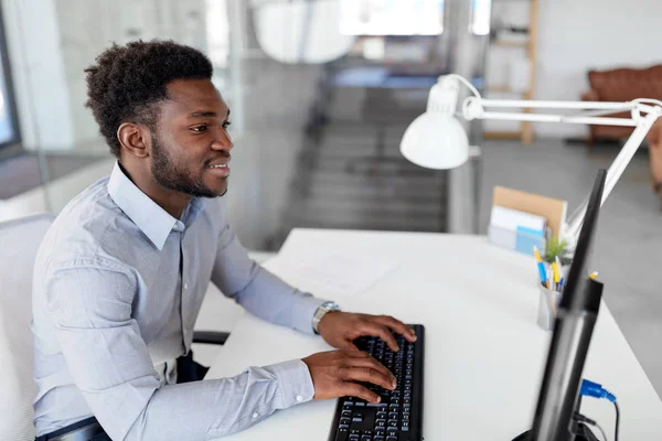 Empresário africano trabalha com computador no escritório — Fotografia de Stock