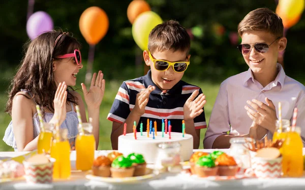Ευτυχής παιδιά με τούρτα στο πάρτι γενεθλίων στο καλοκαίρι — Φωτογραφία Αρχείου