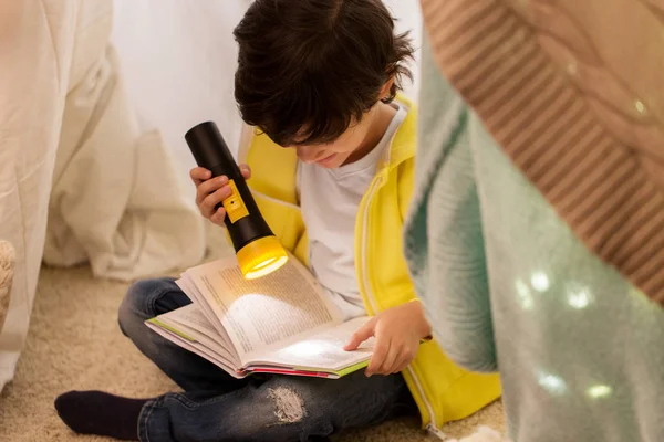 Boldog fiú olvasókönyv gyerekek sátorban otthon Stock Kép