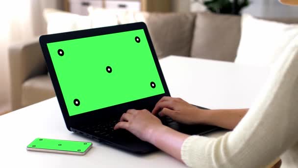 ノート パソコンとスマート フォンに緑色の画面で手 — ストック動画