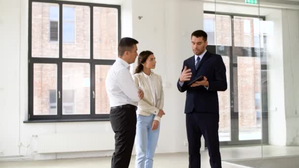 Realtor showing tablet pc to customers at office — Stock Video