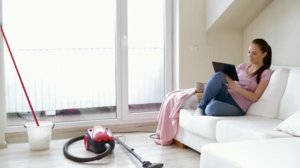 Mujer con tableta PC y té después de la limpieza de casa — Vídeo de stock