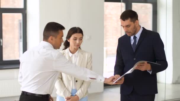 Realtor with folder showing documents to customers — Stock Video