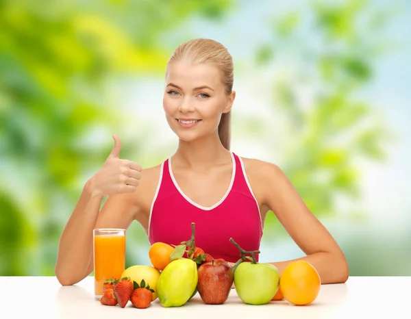 Mulher com frutas e suco mostrando polegares para cima — Fotografia de Stock