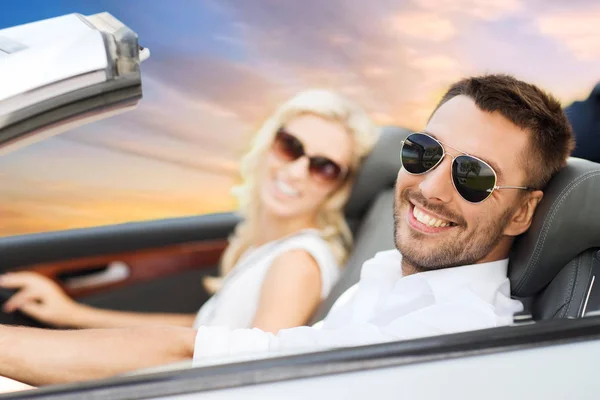 Happy couple driving in convertible car over sky — Stock Photo, Image