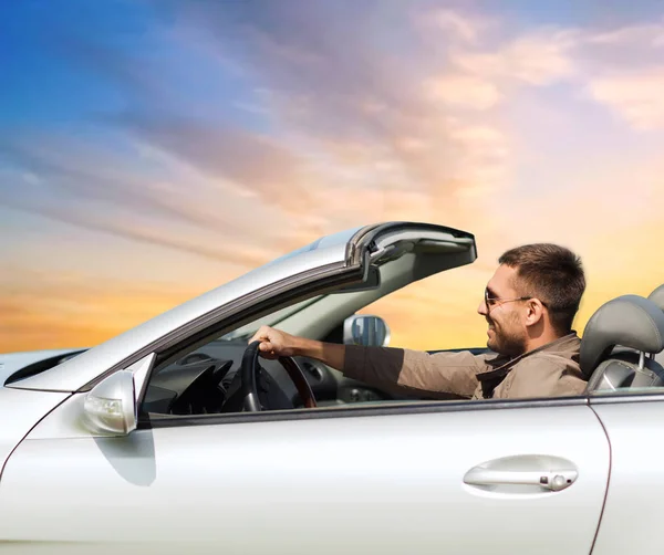 Homem feliz dirigindo carro conversível sobre o céu — Fotografia de Stock