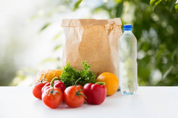 Worek papierowy z warzyw żywności i wody na stole — Zdjęcie stockowe