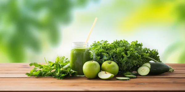 Close up of jug with green juice and vegetables — Stock Photo, Image