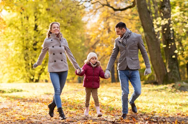 Счастливая семья, гуляющая в осеннем парке — стоковое фото