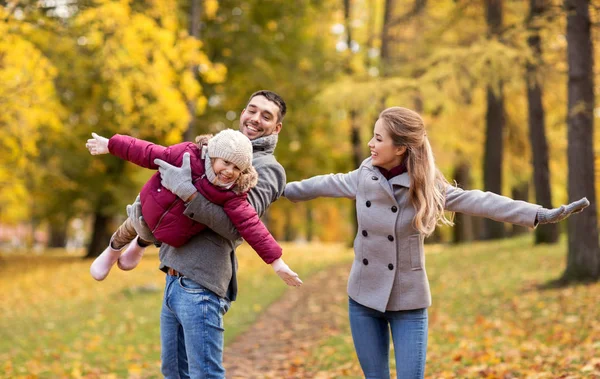 Счастливая семья играет в осеннем парке — стоковое фото