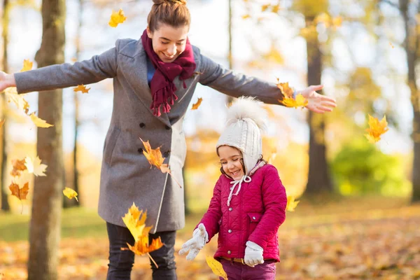 Glückliche Familie spielt im Park mit Herbstlaub — Stockfoto