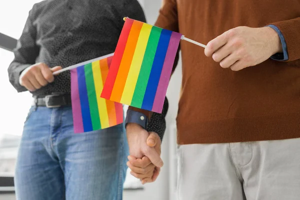 Para mężczyzn z flagami dumy gejowskiej, trzymając się za ręce — Zdjęcie stockowe