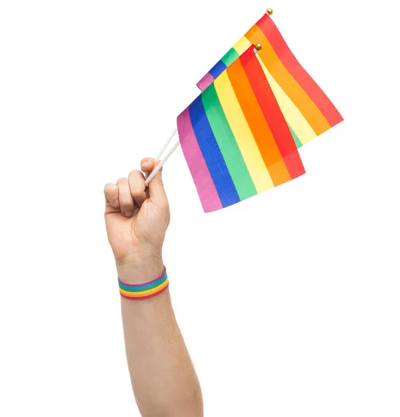 Hand med gay stolthet regnbåge flaggor och armband — Stockfoto