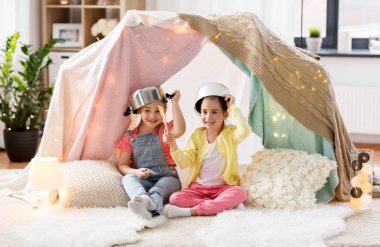 girls with kitchenware playing in tent at home clipart