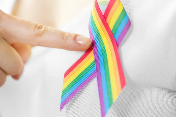 Woman with gay pride awareness ribbon on her chest — Stock Photo, Image