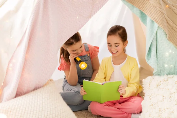 Little girls reading book in kids tent at home — Stock Photo, Image