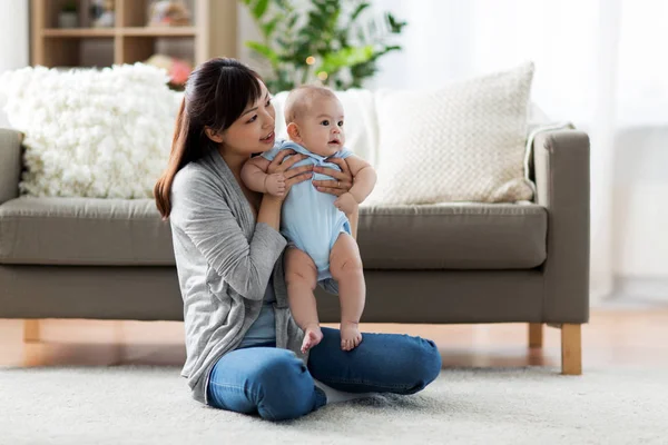 Glückliche junge Mutter mit kleinem Baby zu Hause — Stockfoto